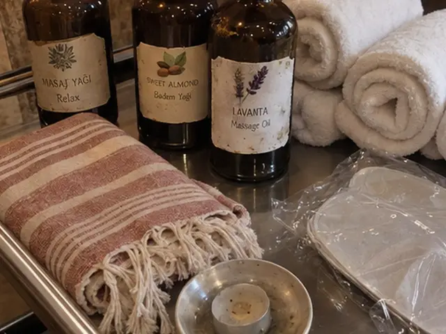 Masaj yağı şişeleri, rulo havlular ve pembe peştemal — Sirkeci, Masaj Salonun